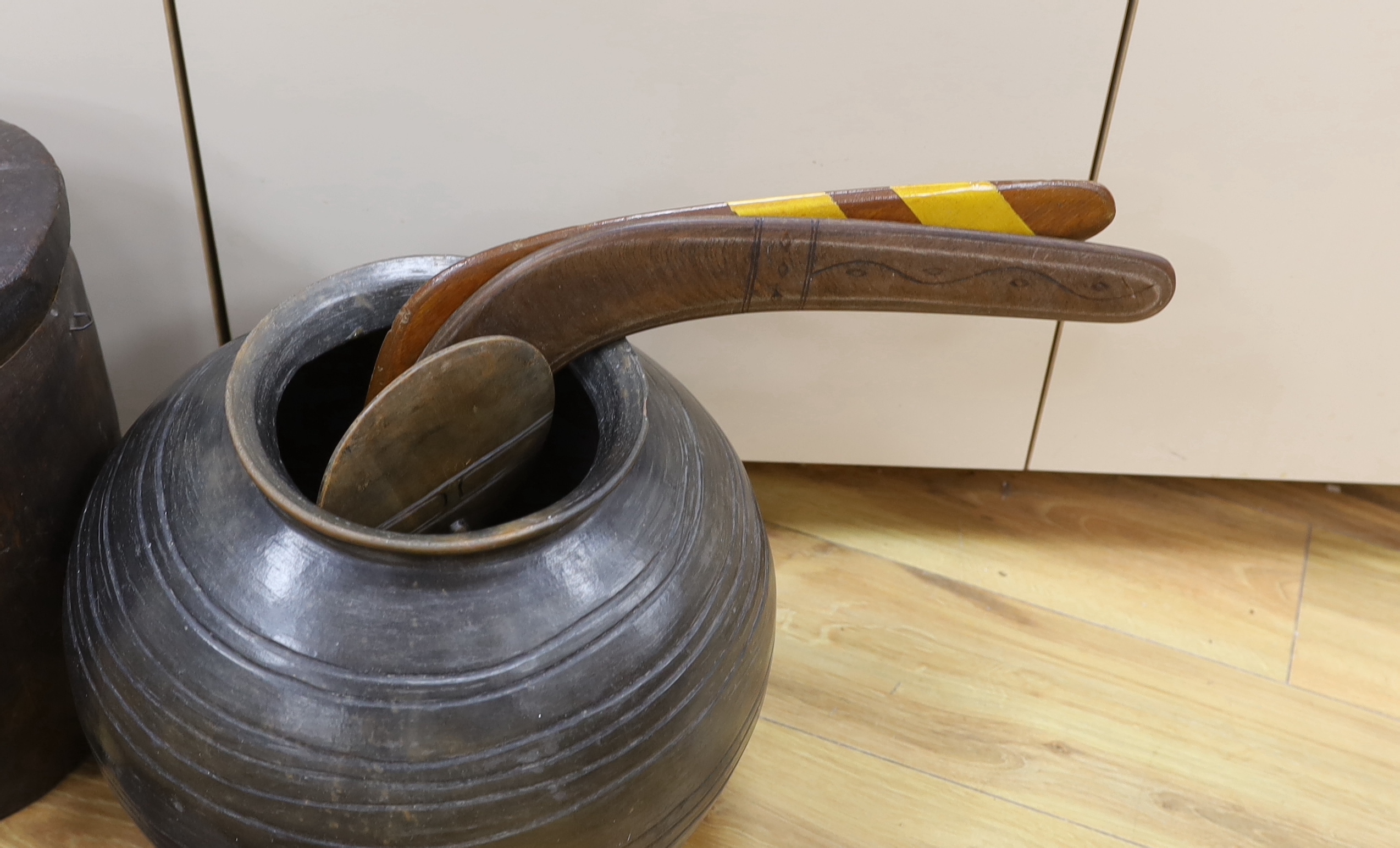 An earthenware bowl, two woven arrow quivers, a bronze pot, a wooden pot and lid, a fertility figure, two boomerangs, etc. (9)